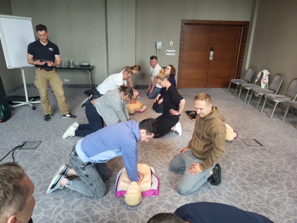 Resuscytacja w rytm muzyki - Ludzie uciskają fantoma w rytm muzyki