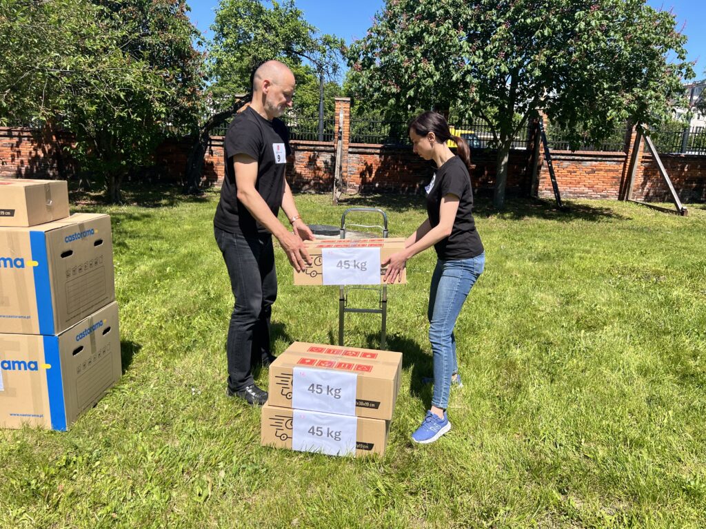 Ręczne prace transportowe a man and woman holding boxes