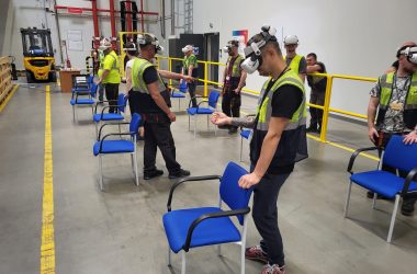 Dzień BHP – szkolenia VR dla dużych grup – sala z krzesłami i okularami – na hali produkcyjnej Dzień BHP – szkolenia VR dla dużych grup - ludzie na hali produkcyjnej grają w okularach VR